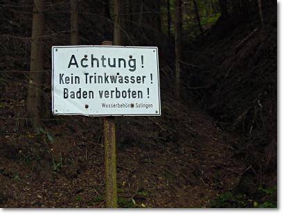 Foto - Hinweisschild mit der Aufschrift: 'Achtung! Kein Trinkwasser! Baden verboten!'