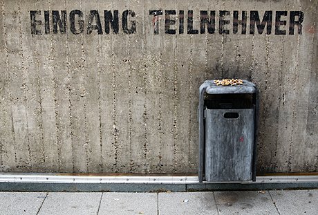 Foto: Mauer mit Schrift und bekipptem Mlleimer