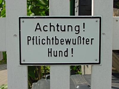 Schild: Achtung! Pflichtbewuter Hund